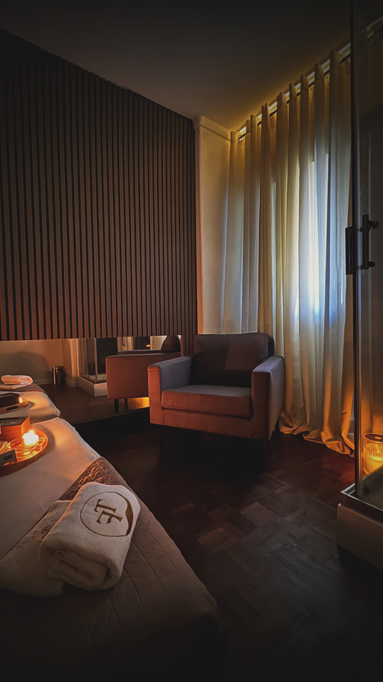 Sala de massagem privada com poltrona, espelho e duche no The Tantric Flow em Lisboa